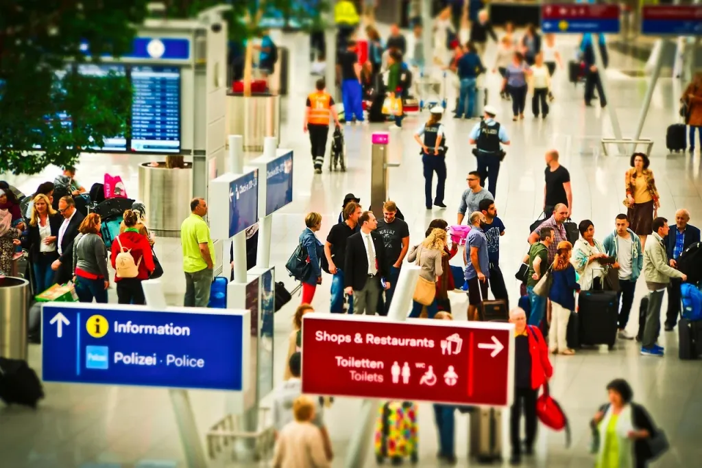 Pasażerowie podczas odprawy biletowo-bagażowej na lotnisku, przygotowujący się do podróży samolotem.